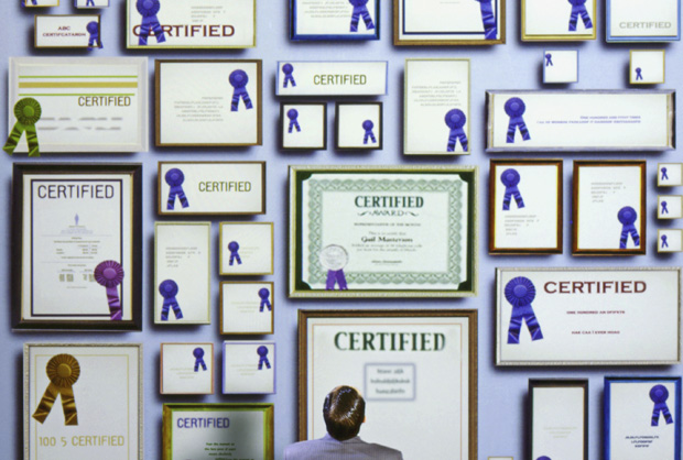 Businessman staring at certificates on wall