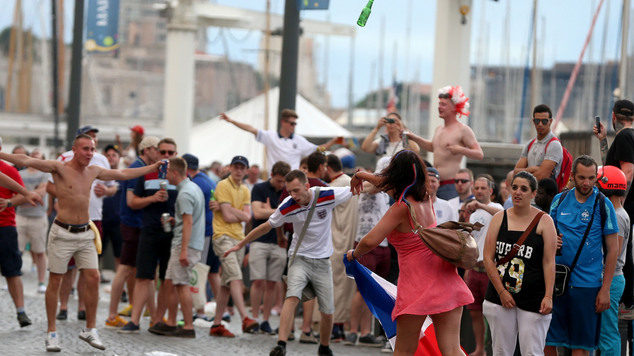 A French woman throws a beer bottle towards English football fans