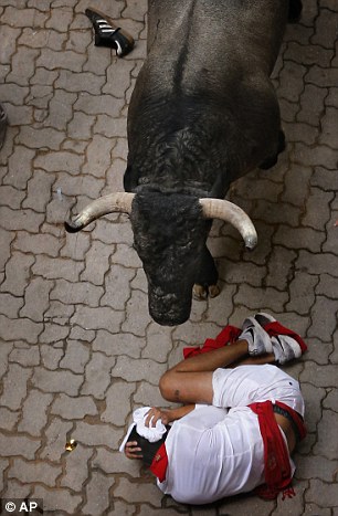 36186FA900000578-0-A_male_runner_cowers_beneath_a_bull_during_the_infamous_Pamplona-a-139_1468102425899