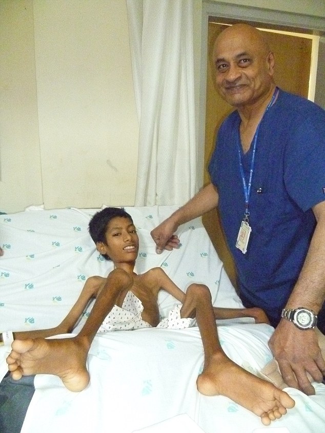 NEW DELHI, INDIA - MARCH, 2016: Dr Rajagopalan Krishnan, a senior consultant and spinal surgeon, with Mahendra after surgery at Apollo Hospital in New Delhi, India. Mahendra Ahirwar, 12, suffered from a rare condition that makes his neck bend and his head hang from his body. He underwent a surgery at Apollo Hospital, in New Delhi. Picture Credit: Cover Asia Press