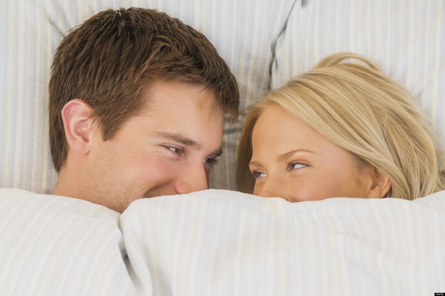 Close up of couple laughing in bed