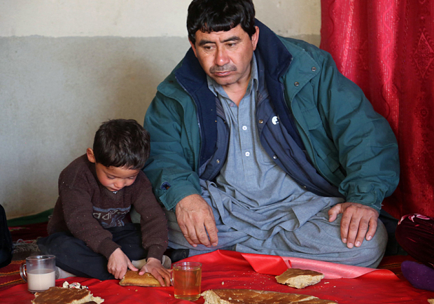In this photograph taken on January 29, 2016, Afghan boy and Lionel Messi fan Murtaza Ahmadi, 5, sits with his father Muhammad Arif Ahmadi, 44, as they eat breakfast at their house in Jaghori district of Ghazni province. A five-year-old Afghan boy has become an internet star after pictures went viral of him wearing an Argentina football shirt made out of a plastic bag, complete with his hero Lionel Messi's name. AFP PHOTOSTR/AFP/Getty Images
