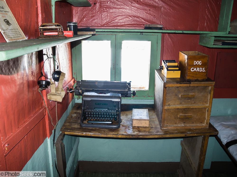 In the Argentine Islands, Antarctica, Wordie House (1947-1954) has been restored and is designated under the Antarctic Treaty System as Historic Site and Monument No. 62. An old manual typewriter and "dog cards" bin rest on a desk. The United Kingdom first established meteorological research here as Base F or "Argentine Islands" on Winter Island in 1947. The main hut, built on the site of an earlier British Graham Land Expedition hut, was named after Sir James Wordie, a member of Shackleton's Imperial Trans-Antarctic Expedition who visited during its construction. The original main hut, "Wordie House," now comprises the kitchen and bunk room. The base was extended in 1951 to include a generator shed, office, store, and toilet. A larger hut was built on nearby Galindez Island in 1954 and renamed Faraday Station in 1977. Researchers at Faraday Station shocked the scientific community by discovering the Antarctic "ozone hole" in 1985. Operational transfer to Ukraine in 1996 renamed Faraday Station to Vernadsky Research Base (Akademik Vernadsky).