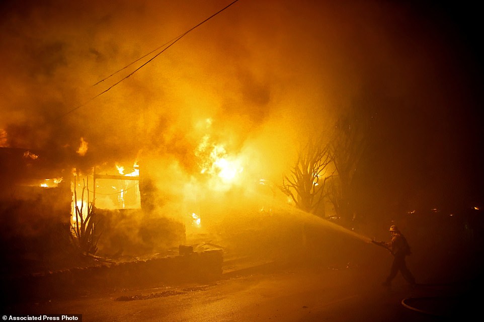 20303870-7623693-A_firefighter_tries_to_hose_down_flames_as_a_home_burns_in_the_G-a-52_1572313073687