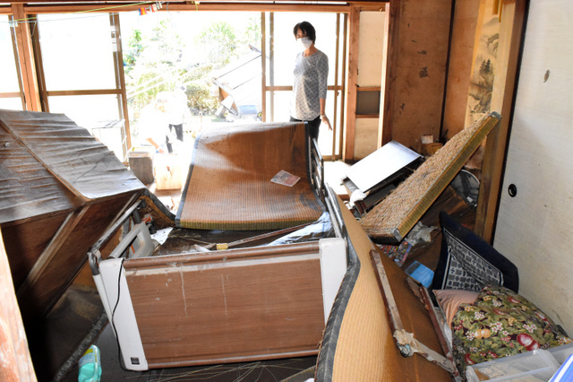 亡くなった岡田コウさん宅。畳やベッドが浮き上がり、水の猛威が伝わる。親戚が後片付けをしていた＝いわき市平赤井