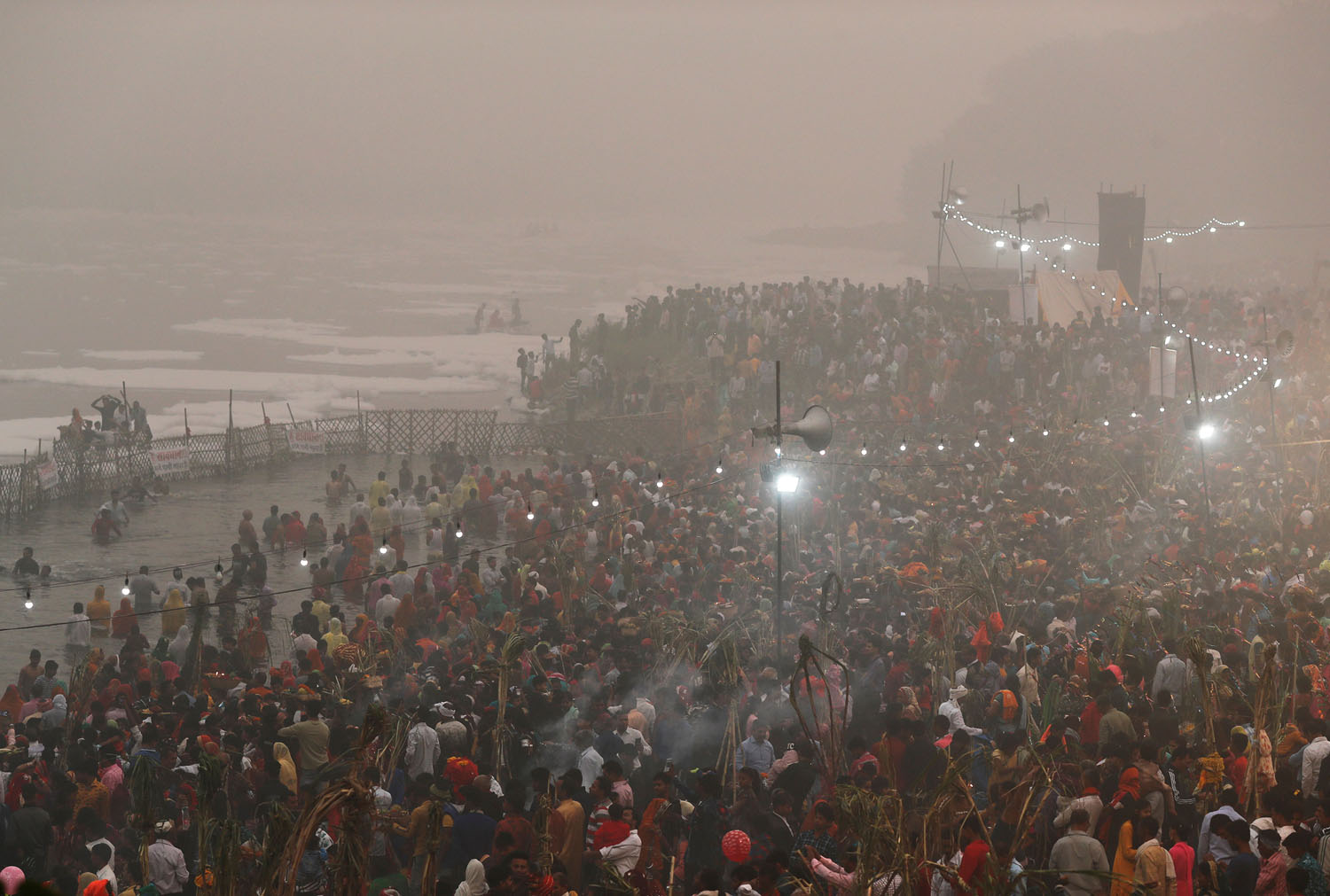 Hindu devotees worship the Sun god in the polluted waters of the river Yamuna during the Hindu religious festival of Chatth Puja in New Delhi