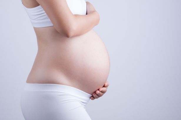0_Midsection-Of-Pregnant-Woman-Touching-Belly-By-Gray-Background.jpg