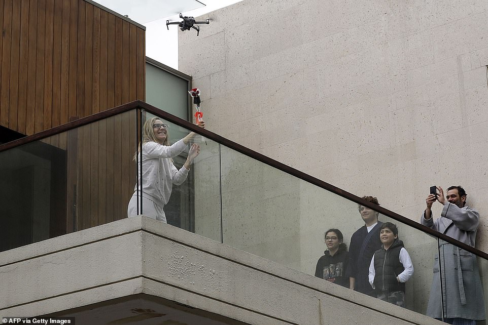 26241238-8137963-A_woman_on_her_balcony_reaches_out_to_catch_a_rose_delivered_to_-a-32_1584804966896
