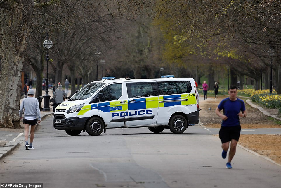 26535120-8163815-A_police_van_drives_past_people_taking_their_daily_exercise_allo-a-4_1585441775971