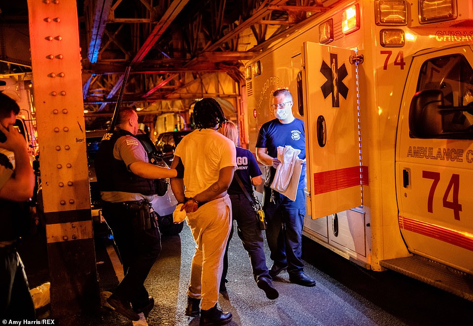 31781918-8611143-An_alleged_looter_is_assisted_by_medics_after_being_detained_in_-a-72_1597091793608.jpg