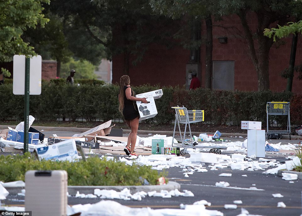 31775580-8611143-A_woman_carries_two_boxes_away_from_Best_Buy_on_Monday_morning_i-a-89_1597091793625.jpg