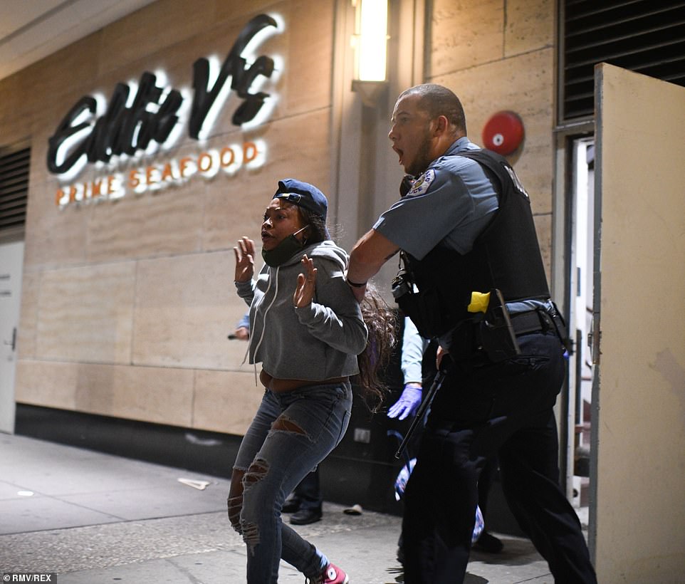 31781910-8611143-Chicago_police_officers_grab_a_woman_attempting_to_run_from_a_st-a-73_1597091793609.jpg