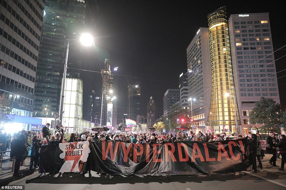 34742612-8868417-Protesters_hold_up_a_banner_translating_as_f_off_during_the_prot-a-12_1603441427012